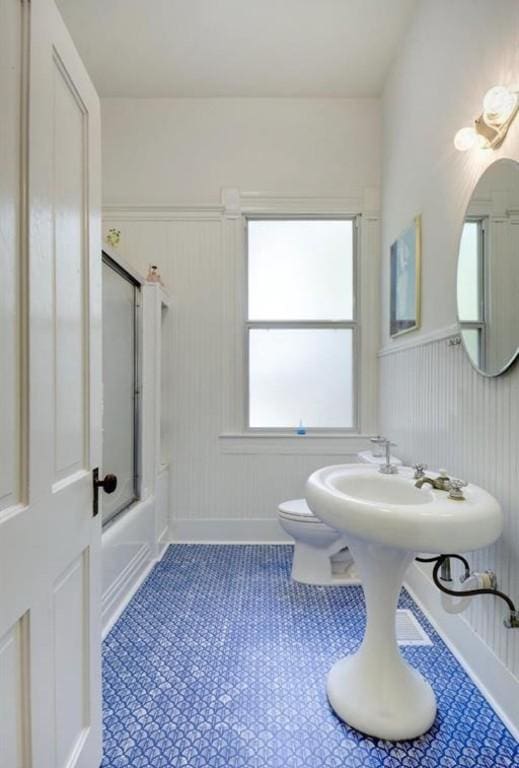 200 Garwood St, Smithville, TX 78957 - bathroom with wainscoting,  shower combination, and a decorative wall