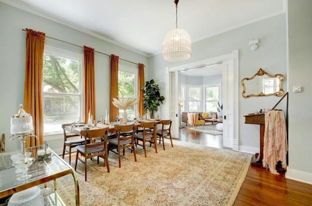 200 Garwood St, Smithville, TX 78957 - dining area featuring healthy amount of natural light, a chandelier, wood finished floors, and crown molding