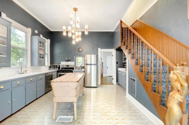 200 Garwood St, Smithville, TX 78957 - kitchen featuring appliances with stainless steel finishes, light flooring, a chandelier, light countertops, and crown molding