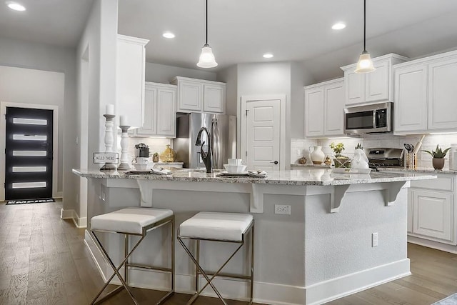 113 Charro Ct, Georgetown, TX 78633 - kitchen with appliances with stainless steel finishes, decorative backsplash, a peninsula, white cabinetry, and light stone counters