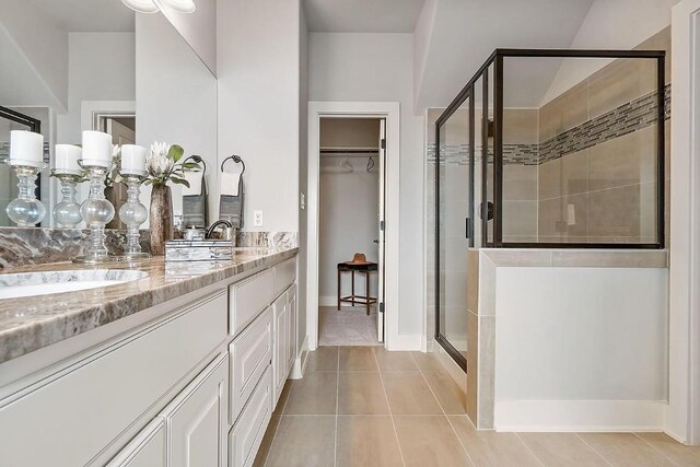 113 Charro Ct, Georgetown, TX 78633 - bathroom with a stall shower, double vanity, tile patterned flooring, and a walk in closet