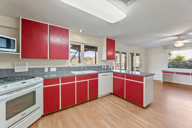 3309 Westhill Unit A & B, Austin, TX 78704 - kitchen featuring red cabinets, white appliances, light wood-style floors, a peninsula, and recessed lighting