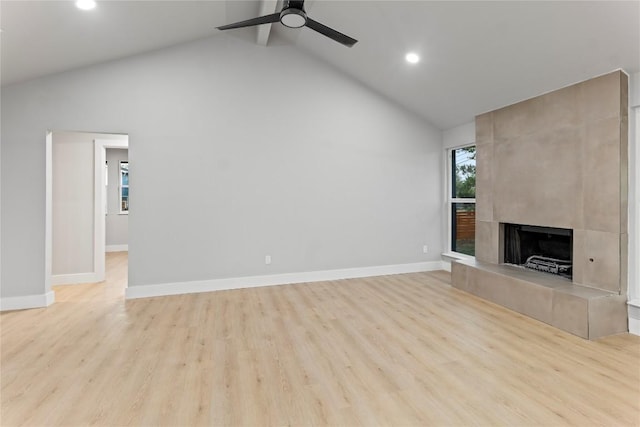 3907 Carmel Dr, Austin, TX 78721 - unfurnished living room with high vaulted ceiling, a ceiling fan, recessed lighting, a tile fireplace, and wood finished floors