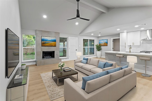 3907 Carmel Dr, Austin, TX 78721 - living area with beamed ceiling, light wood-style floors, a ceiling fan, a fireplace, and recessed lighting
