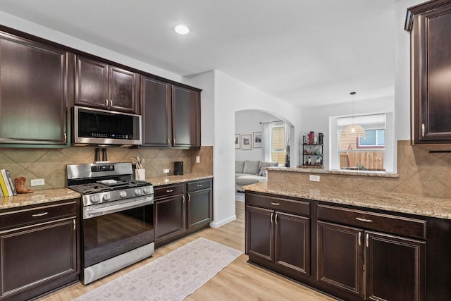 1620 Rockland Dr Unit 167, Austin, TX 78748 - kitchen featuring appliances with stainless steel finishes, arched walkways, light wood-style floors, dark brown cabinets, and recessed lighting