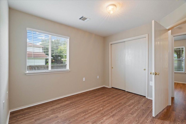 11617 Briarcreek Loop, Manor, TX 78653 - unfurnished bedroom with wood finished floors, multiple windows, and a closet