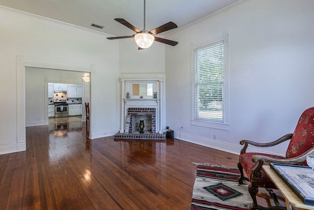 618 N Penelope St, Belton, TX 76513 - living room with a ceiling fan, dark wood-type flooring, crown molding, and a fireplace