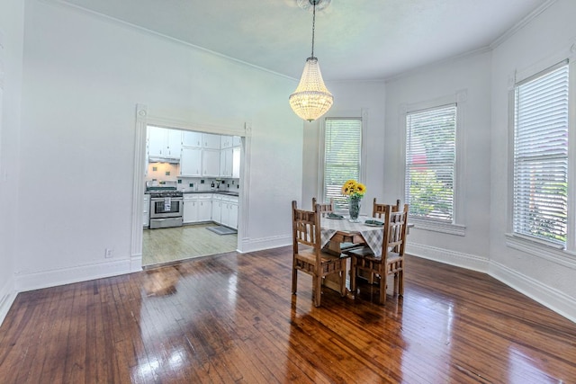 618 N Penelope St, Belton, TX 76513 - dining area with a chandelier, healthy amount of natural light, dark wood-style flooring, and crown molding