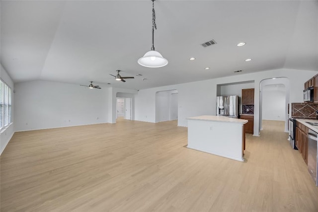 19700 San Chisolm Dr, Round Rock, TX 78664 - kitchen with stainless steel appliances, arched walkways, a kitchen island, light wood-type flooring, and decorative light fixtures