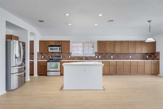 19700 San Chisolm Dr, Round Rock, TX 78664 - kitchen with appliances with stainless steel finishes, light wood finished floors, brown cabinetry, decorative backsplash, and recessed lighting