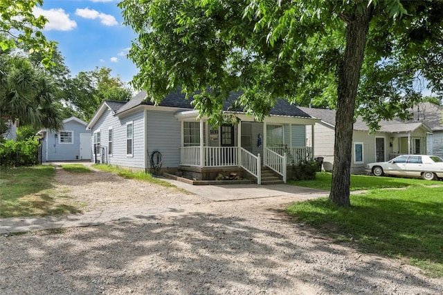 1211 S 17th St, Temple, TX 76504 - view of front of house with covered porch, dirt driveway, a front lawn, and roof with shingles
