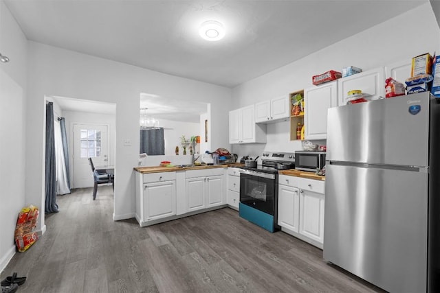 1211 S 17th St, Temple, TX 76504 - kitchen with stainless steel appliances, white cabinetry, wood finished floors, and a chandelier