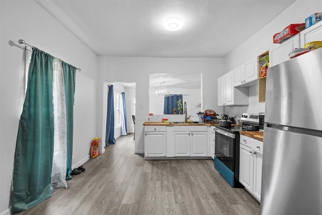 1211 S 17th St, Temple, TX 76504 - kitchen with freestanding refrigerator, electric range, white cabinets, butcher block counters, and light wood-style floors
