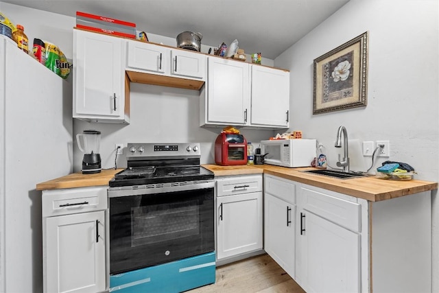 1211 S 17th St, Temple, TX 76504 - kitchen featuring white appliances, butcher block countertops, white cabinets, and light wood finished floors