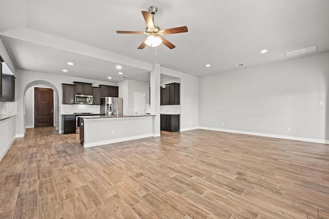 19113 Melwas Way, Pflugerville, TX 78660 - unfurnished living room featuring ceiling fan, light wood-style flooring, arched walkways, and recessed lighting