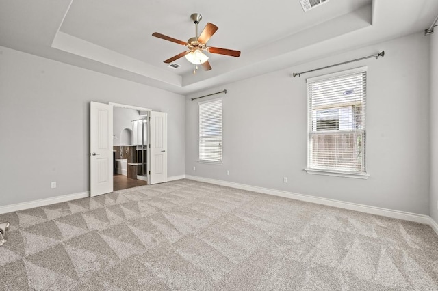 19113 Melwas Way, Pflugerville, TX 78660 - unfurnished bedroom featuring a tray ceiling, carpet floors, and connected bathroom