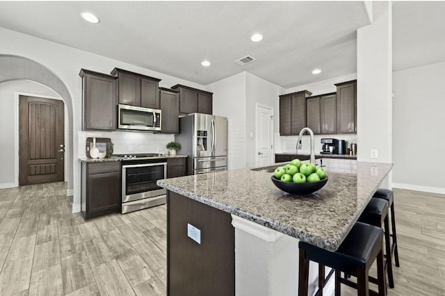 19113 Melwas Way, Pflugerville, TX 78660 - kitchen featuring stainless steel appliances, dark brown cabinets, light wood-type flooring, and recessed lighting