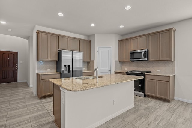205 Falkland St, Hutto, TX 78634 - kitchen featuring appliances with stainless steel finishes, backsplash, light stone counters, recessed lighting, and an island with sink