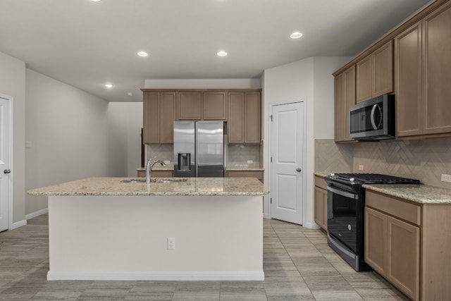 205 Falkland St, Hutto, TX 78634 - kitchen featuring stainless steel appliances, an island with sink, light stone counters, and recessed lighting