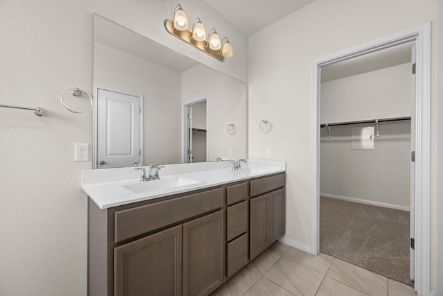 205 Falkland St, Hutto, TX 78634 - bathroom featuring double vanity, a walk in closet, and tile patterned flooring