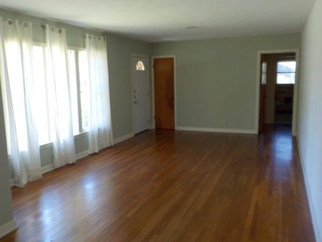 1721 E 32nd St, Austin, TX 78722 - unfurnished living room featuring plenty of natural light and wood finished floors