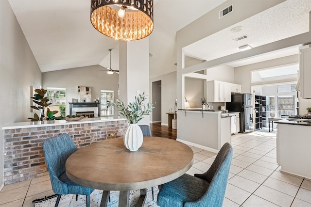 8204 Cahill Dr, Austin, TX 78729 - dining space featuring light tile patterned flooring, ceiling fan, a chandelier, and high vaulted ceiling