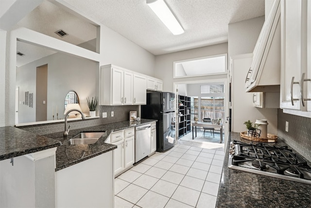 8204 Cahill Dr, Austin, TX 78729 - kitchen with appliances with stainless steel finishes, tasteful backsplash, white cabinetry, a textured ceiling, and a high ceiling