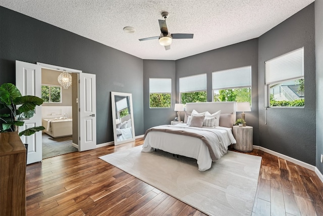 8204 Cahill Dr, Austin, TX 78729 - bedroom with multiple windows, wood-type flooring, a textured wall, a textured ceiling, and a chandelier