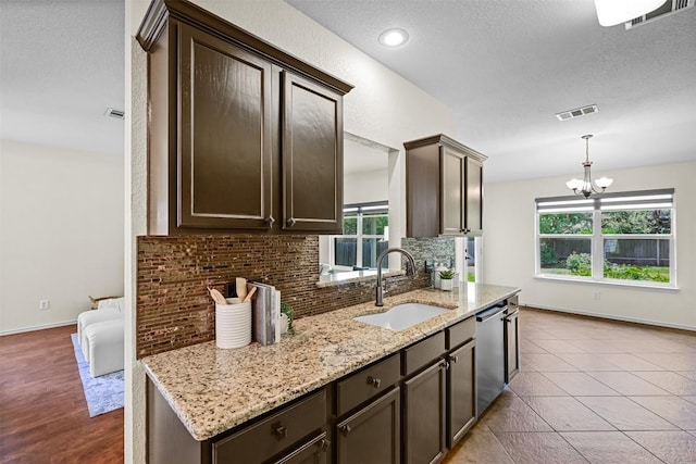 3305 Blue Ridge Dr, Round Rock, TX 78681 - kitchen with dark brown cabinets, dishwasher, tasteful backsplash, light stone countertops, and a chandelier