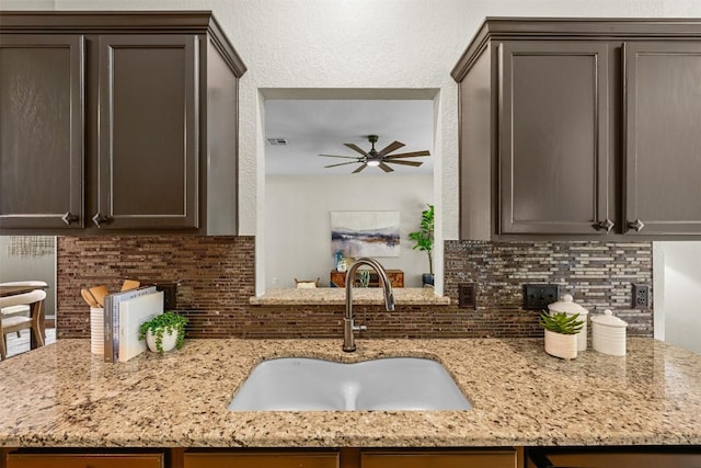 3305 Blue Ridge Dr, Round Rock, TX 78681 - kitchen with tasteful backsplash, ceiling fan, light stone counters, and dark brown cabinetry