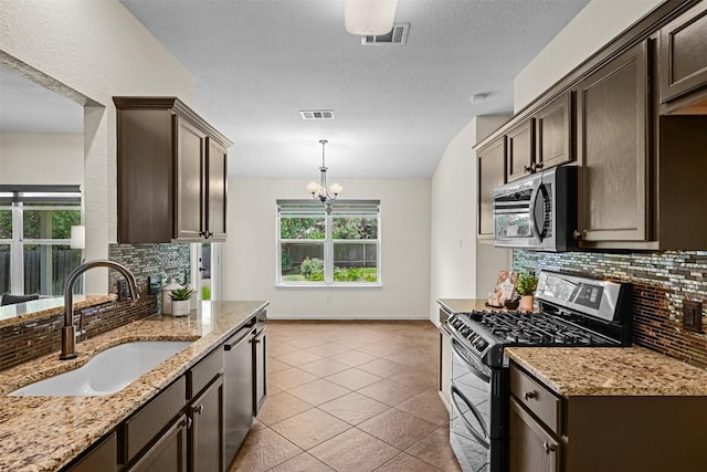 3305 Blue Ridge Dr, Round Rock, TX 78681 - kitchen with appliances with stainless steel finishes, dark brown cabinets, backsplash, and plenty of natural light