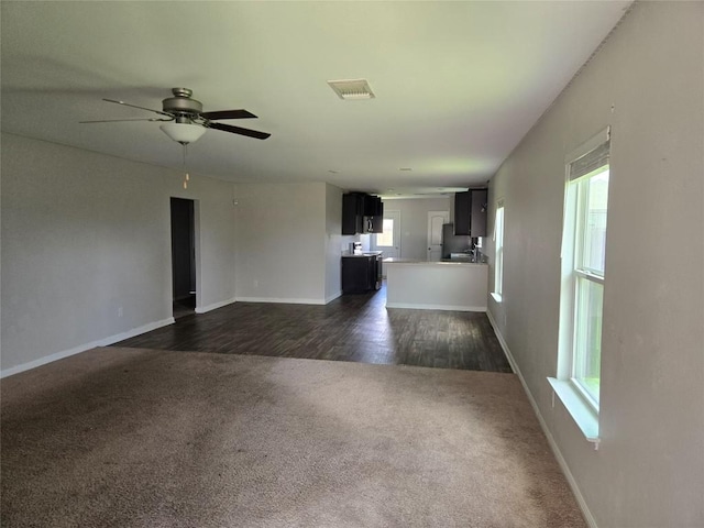 16416 Farmhouse Ln, Elgin, TX 78621 - unfurnished living room with dark colored carpet, a ceiling fan, and dark wood-style flooring