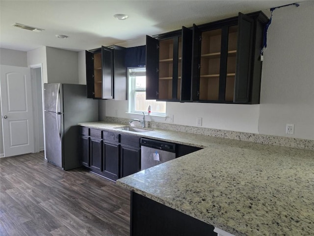 16416 Farmhouse Ln, Elgin, TX 78621 - kitchen with stainless steel appliances, dark wood finished floors, light stone countertops, and glass insert cabinets