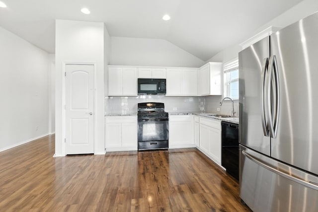 337 Spiny Lizard Ln, San Marcos, TX 78666 - kitchen with black appliances, light stone countertops, lofted ceiling, decorative backsplash, and white cabinetry