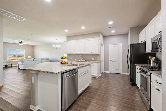 316 Shiner Ln, Georgetown, TX 78626 - kitchen featuring stainless steel appliances, open floor plan, dark wood finished floors, white cabinetry, and recessed lighting