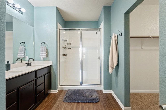 316 Shiner Ln, Georgetown, TX 78626 - bathroom featuring a stall shower, wood finished floors, double vanity, and a spacious closet