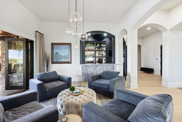 1216 Travis Bluff Way, Spicewood, TX 78669 - living area with arched walkways, wood finished floors, and a bar