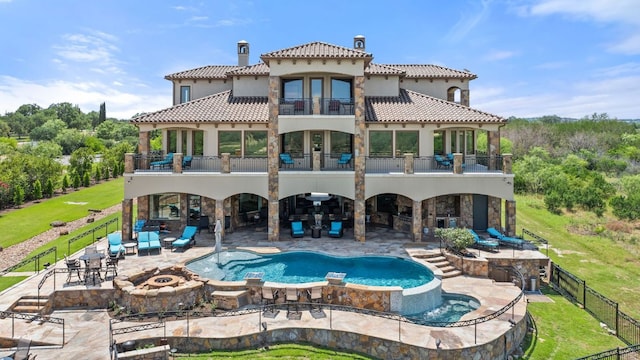 1216 Travis Bluff Way, Spicewood, TX 78669 - back of house with a balcony, a patio, a pool with connected hot tub, and a fenced backyard