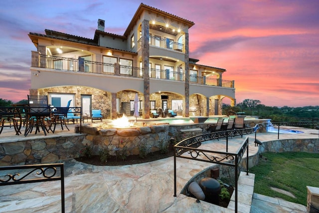 1216 Travis Bluff Way, Spicewood, TX 78669 - rear view of property with a balcony, a patio, a pool with connected hot tub, and stucco siding