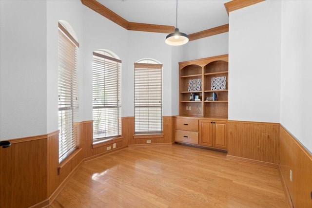 2905 Post River Rd, Cedar Park, TX 78613 - unfurnished dining area with a wainscoted wall, ornamental molding, light wood finished floors, and wood walls