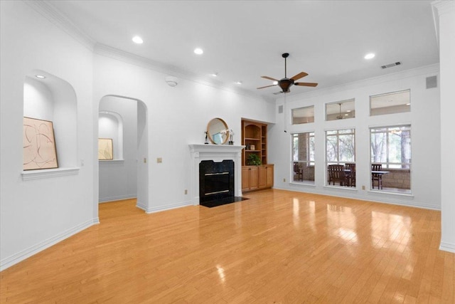 2905 Post River Rd, Cedar Park, TX 78613 - unfurnished living room featuring crown molding, ceiling fan, light wood-style flooring, recessed lighting, and arched walkways
