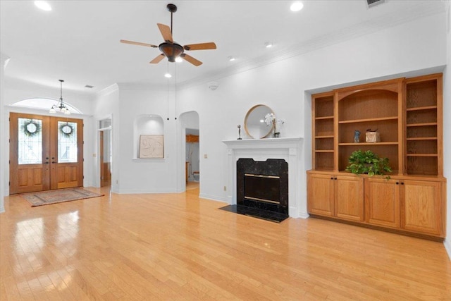 2905 Post River Rd, Cedar Park, TX 78613 - unfurnished living room with a ceiling fan, light wood-style flooring, ornamental molding, french doors, and a high end fireplace