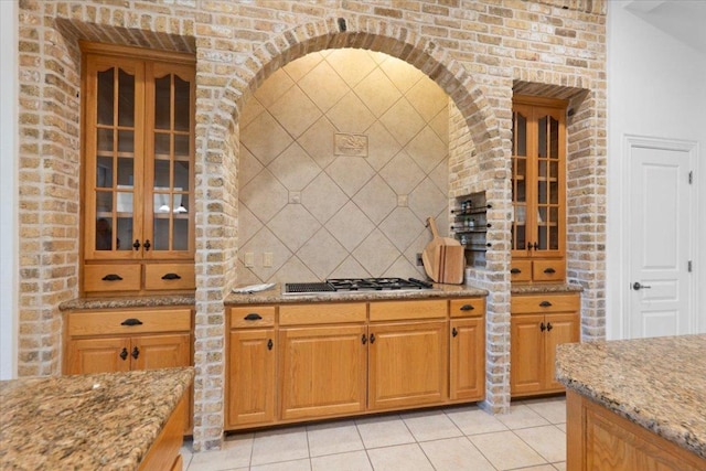 2905 Post River Rd, Cedar Park, TX 78613 - kitchen with stainless steel gas cooktop, light stone countertops, light tile patterned flooring, and glass insert cabinets