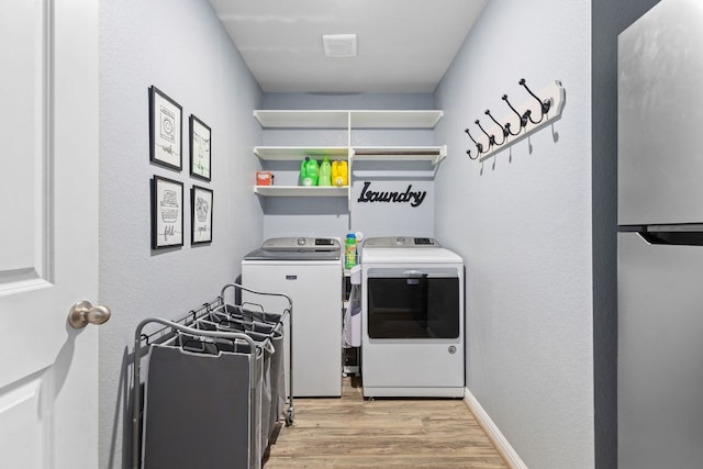 6045 Teodoro Bnd, Round Rock, TX 78665 - laundry room with washer and dryer and light wood-style flooring