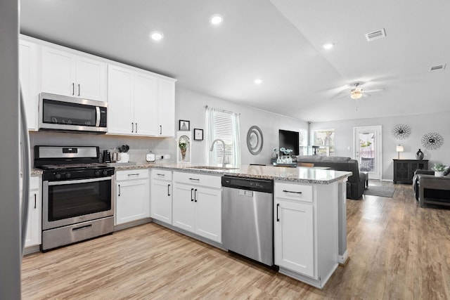 6045 Teodoro Bnd, Round Rock, TX 78665 - kitchen with appliances with stainless steel finishes, a peninsula, a ceiling fan, white cabinets, and open floor plan