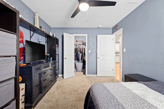 6045 Teodoro Bnd, Round Rock, TX 78665 - bedroom with light carpet, a walk in closet, a closet, and ceiling fan