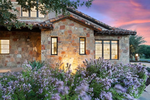 205 Hi Ridge Rd, Horseshoe Bay, TX 78657 - property exterior at dusk with stone siding and a tiled roof