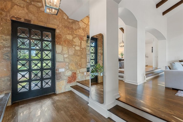 205 Hi Ridge Rd, Horseshoe Bay, TX 78657 - foyer with arched walkways, wood finished floors, high vaulted ceiling, beam ceiling, and stairway