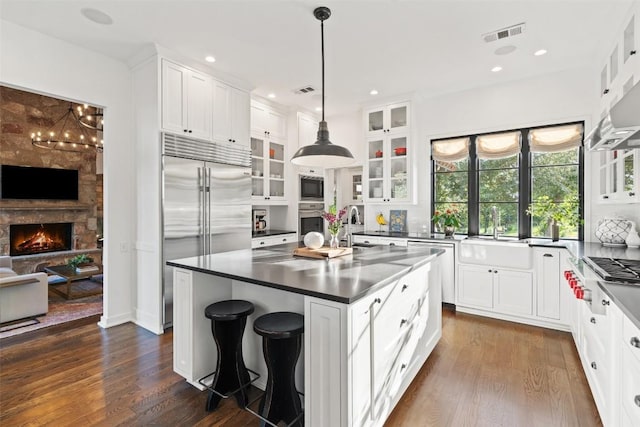 205 Hi Ridge Rd, Horseshoe Bay, TX 78657 - kitchen featuring built in appliances, glass insert cabinets, dark wood finished floors, white cabinetry, and recessed lighting