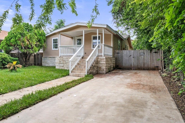 7309 Blessing Ave, Austin, TX 78752 - view of front facade with covered porch, a gate, and concrete driveway